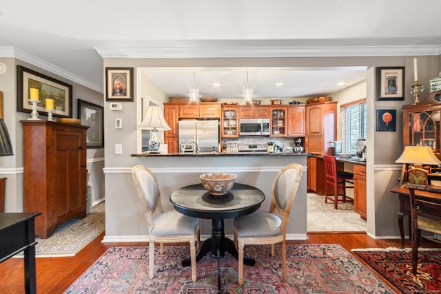 dining area featuring light hardwood / wood-style flooring and ornamental molding