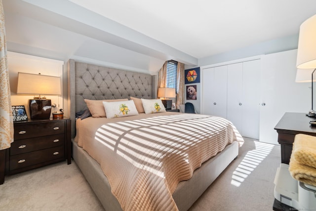 bedroom featuring light colored carpet and a closet