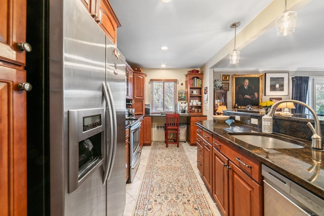 kitchen with stainless steel appliances, sink, dark stone countertops, hanging light fixtures, and light tile patterned flooring