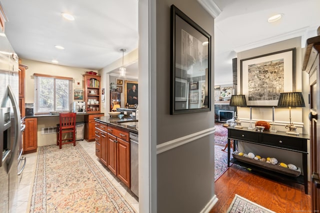 kitchen with hardwood / wood-style flooring, decorative light fixtures, stainless steel dishwasher, and ornamental molding