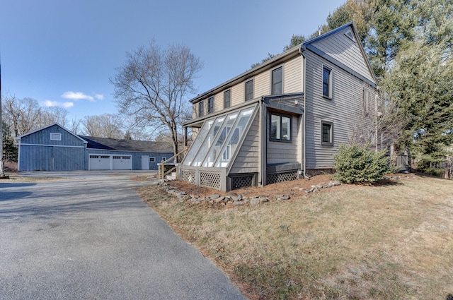 view of home's exterior with a garage and a lawn