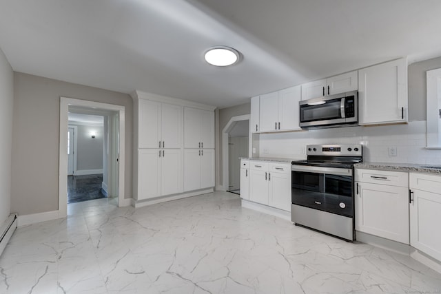 kitchen with appliances with stainless steel finishes, white cabinets, light stone counters, and decorative backsplash