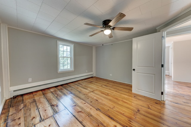 spare room featuring crown molding, a baseboard radiator, and light hardwood / wood-style floors