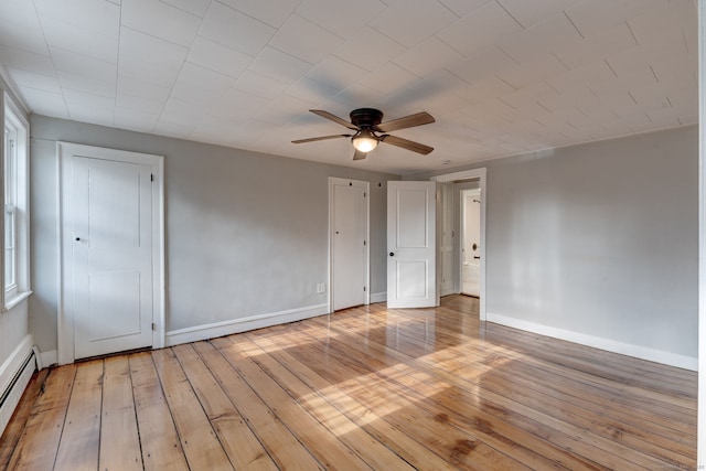 unfurnished bedroom with light hardwood / wood-style flooring, ceiling fan, and baseboard heating