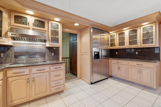 kitchen with built in fridge, black electric stovetop, decorative backsplash, light tile patterned floors, and range hood