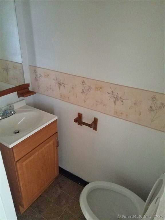 bathroom with tile patterned flooring, vanity, and toilet