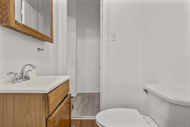 bathroom with hardwood / wood-style flooring, vanity, and toilet