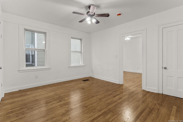 unfurnished room with ceiling fan and dark hardwood / wood-style flooring