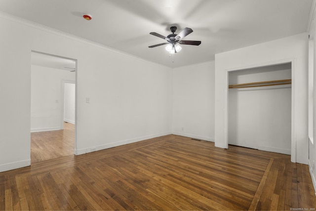 unfurnished bedroom featuring ceiling fan, a closet, crown molding, and dark hardwood / wood-style floors