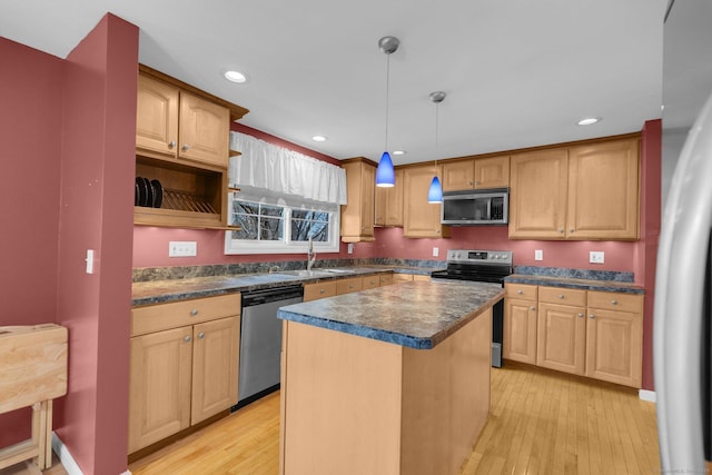 kitchen featuring light hardwood / wood-style flooring, pendant lighting, stainless steel appliances, a kitchen island, and sink