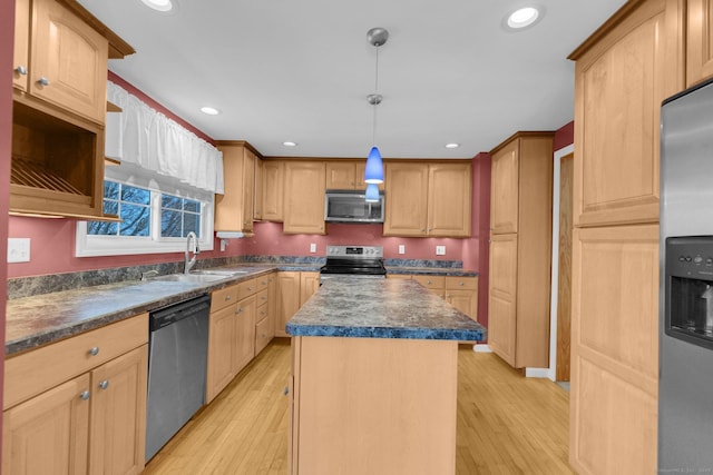 kitchen with sink, a kitchen island, light hardwood / wood-style flooring, and appliances with stainless steel finishes