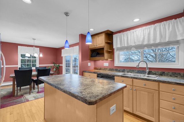 kitchen featuring a center island, light wood-type flooring, a notable chandelier, and sink