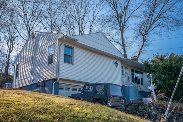 view of side of home with a garage and a yard