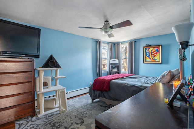 bedroom with ceiling fan, a baseboard radiator, and wood-type flooring