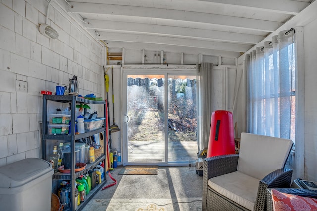 living area with carpet flooring, plenty of natural light, and beam ceiling