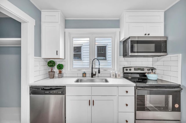 kitchen featuring backsplash, stainless steel appliances, white cabinetry, and sink