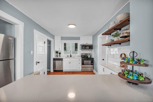 kitchen featuring white cabinetry, sink, appliances with stainless steel finishes, and tasteful backsplash