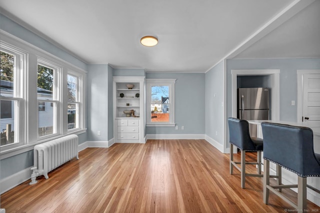 dining room featuring radiator heating unit and light wood-type flooring