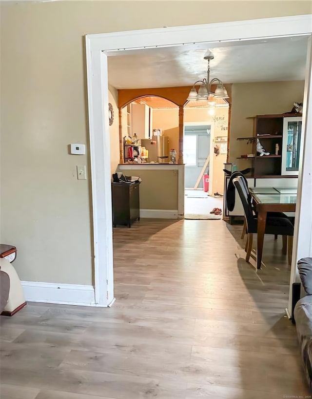 dining area with light hardwood / wood-style floors and a chandelier