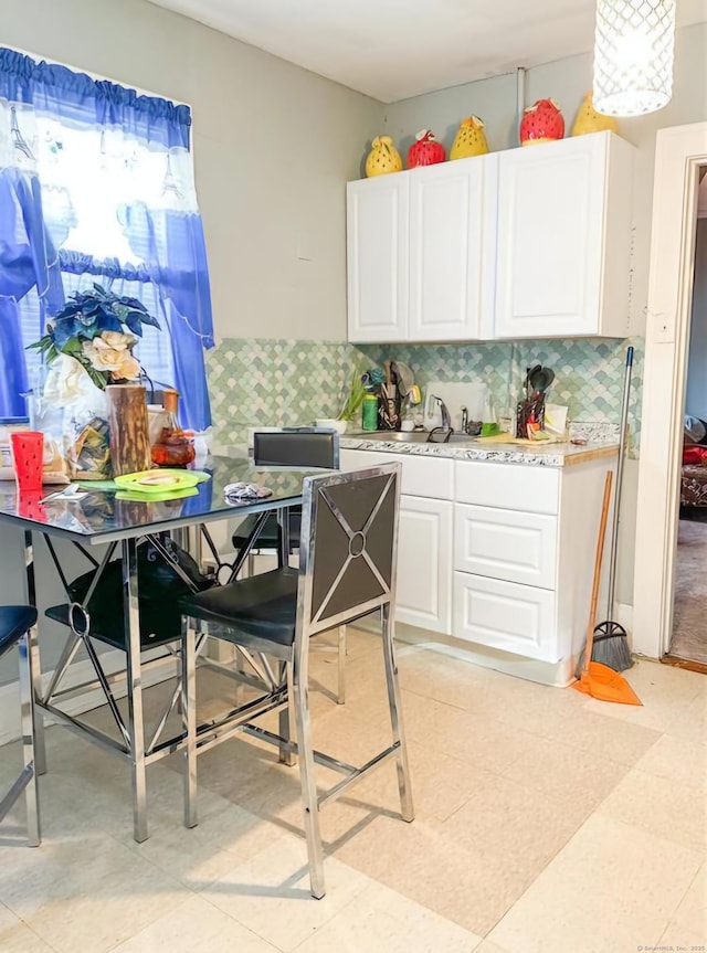 kitchen featuring decorative backsplash, sink, and white cabinets