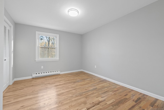 spare room with a baseboard radiator and light hardwood / wood-style flooring