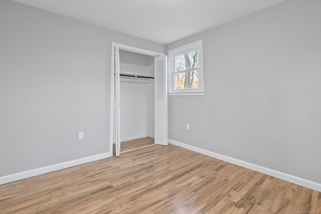 unfurnished bedroom with light hardwood / wood-style flooring and a closet