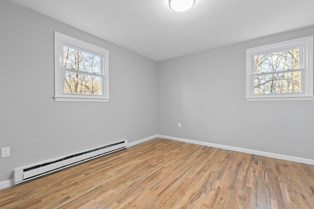 spare room with a baseboard radiator and light hardwood / wood-style floors