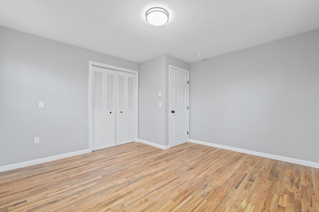 unfurnished bedroom featuring a closet and light hardwood / wood-style flooring