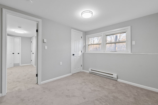 spare room featuring light colored carpet and a baseboard radiator