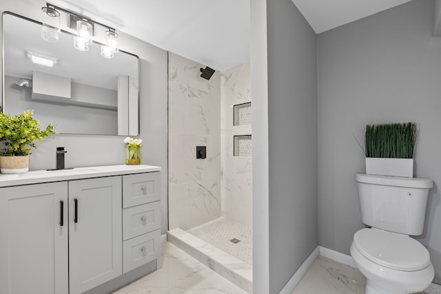 bathroom with toilet, a tile shower, and vanity