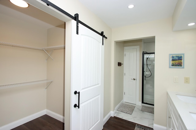 bathroom with a shower with shower door and vanity