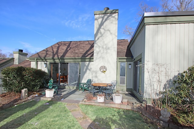 back of property with a yard and a patio