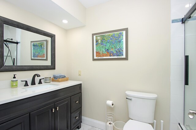 bathroom featuring toilet, vanity, and a shower with shower door