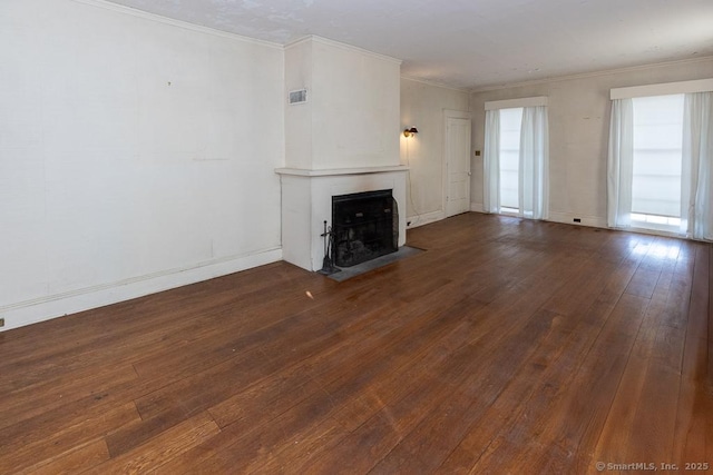 unfurnished living room featuring ornamental molding and dark hardwood / wood-style floors