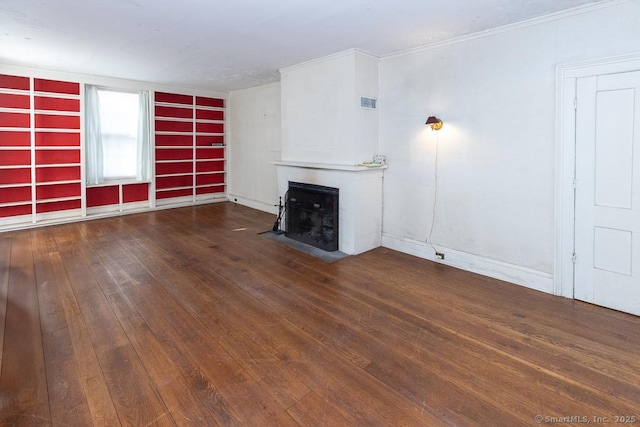 unfurnished living room with crown molding and dark hardwood / wood-style flooring