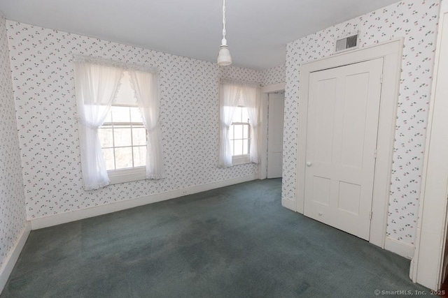 unfurnished room featuring dark carpet