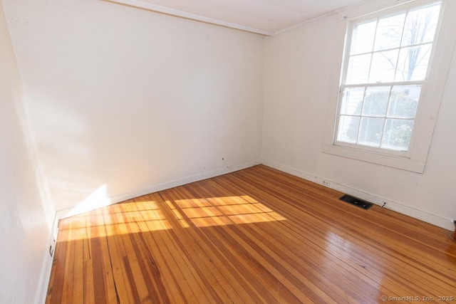 unfurnished room featuring hardwood / wood-style floors and crown molding