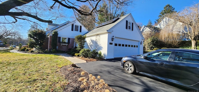 view of side of home featuring a lawn, an outdoor structure, and a garage