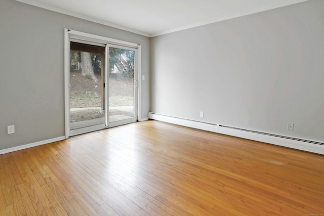 spare room featuring crown molding, light wood-type flooring, and baseboard heating