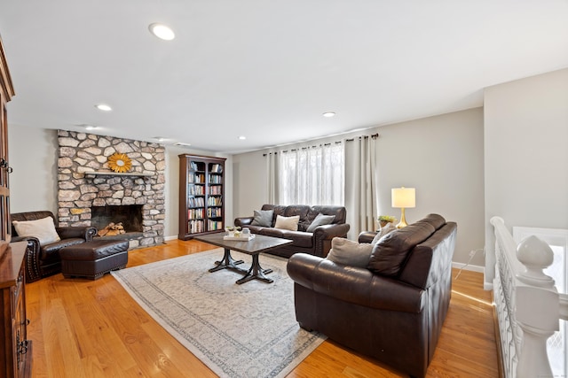 living room with a fireplace and light wood-type flooring