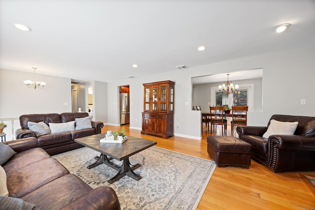 living room featuring light hardwood / wood-style floors and an inviting chandelier