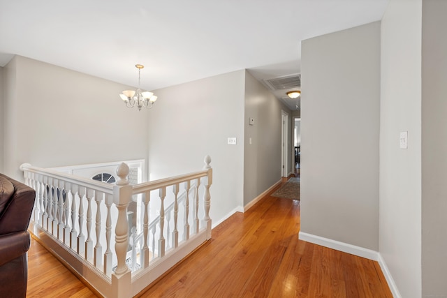 hallway with a chandelier and light wood-type flooring