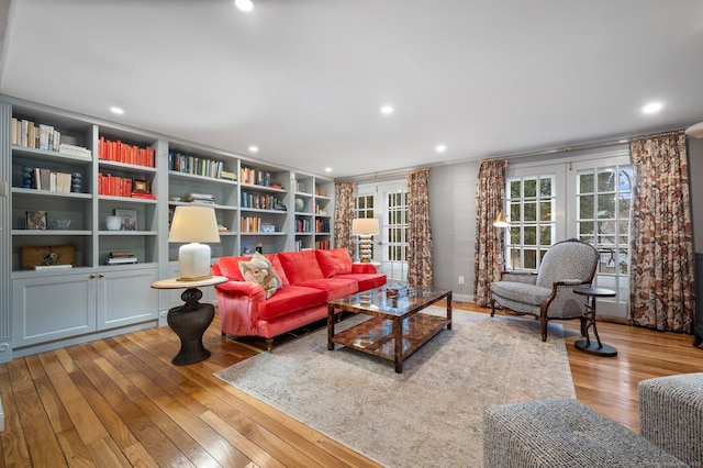 living room with french doors, built in features, and light hardwood / wood-style flooring