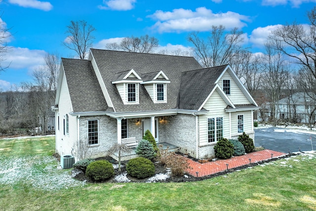 view of front of home featuring covered porch, a front yard, and central air condition unit