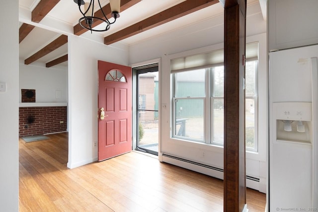 foyer with a notable chandelier, plenty of natural light, beam ceiling, and brick wall