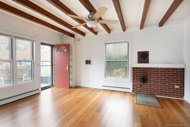 unfurnished living room with light wood-type flooring, a baseboard radiator, and plenty of natural light