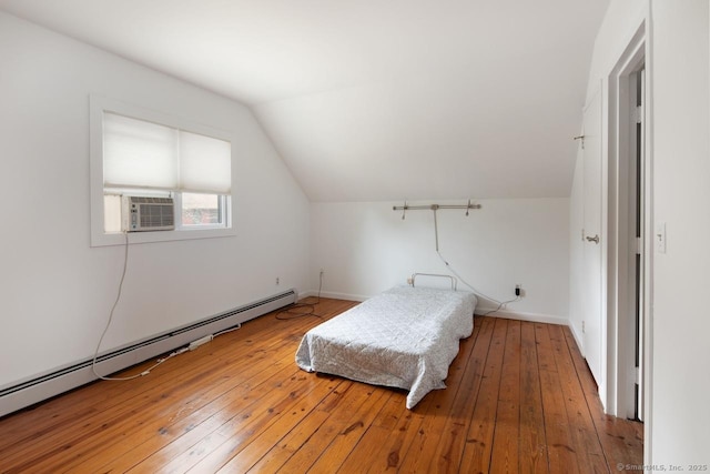 bedroom featuring hardwood / wood-style flooring, baseboard heating, and vaulted ceiling