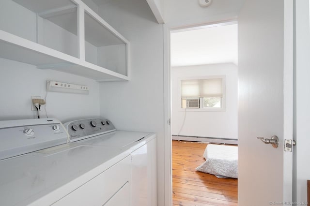 laundry room with washing machine and dryer, light hardwood / wood-style flooring, and a baseboard heating unit