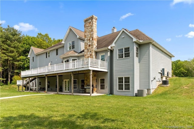 rear view of house featuring a lawn, a wooden deck, a patio area, and central air condition unit