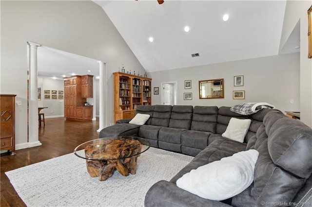 living room featuring decorative columns, high vaulted ceiling, and dark wood-type flooring